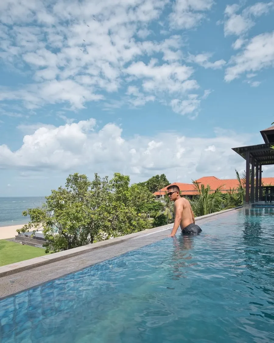 Agung Afif in an infinity pool overlooking the sea
